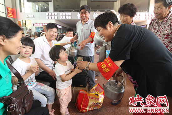 老年雷鋒團(tuán)”志愿者在候車廳為旅客送水。