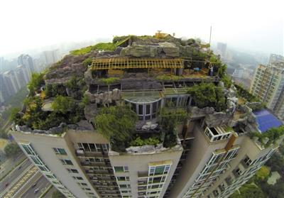 　　昨日，身穿橘黃色馬甲的工作人員在人濟(jì)山莊樓頂拆除違章建筑。新京報(bào)記者 吳江 攝