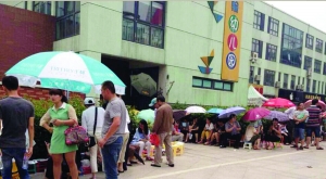 金壇市實(shí)驗(yàn)幼兒園門(mén)前，家長(zhǎng)在排隊(duì)