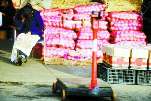 水果批發(fā)市場(chǎng)內(nèi)，沒(méi)有客戶(hù)時(shí)，商戶(hù)在繡十字繡