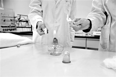 實驗人員操作的燃燒檢測法中，真蠶絲離開火焰就熄滅(左)。