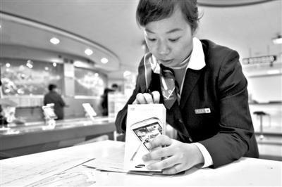 11月6日，北京移動西直門營業(yè)廳的工作人員在為顧客購買的4G手機登記。新華社發(fā)