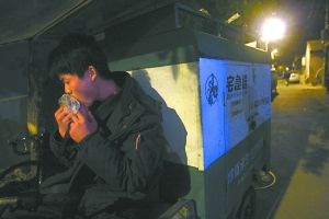 快遞哥抽空吃兩口東西。記者 李剛 攝