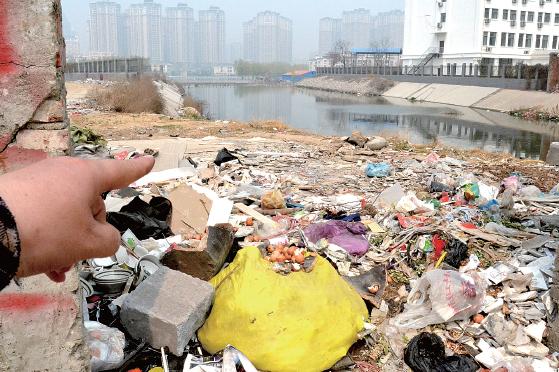 金水河長(zhǎng)江路橋下河水發(fā)臭，水邊堆放眾多垃圾
