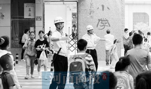伊河路小學(xué)門(mén)口，兩名巡防隊(duì)員護(hù)送學(xué)生過(guò)馬路