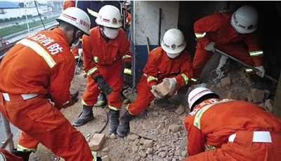 消防人員在清理熔鹽爐倒塌的廢墟。