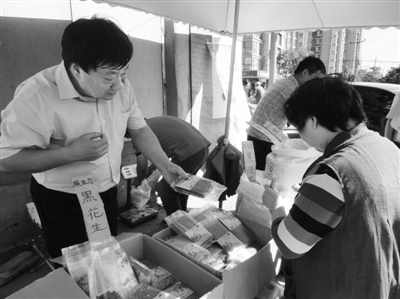 昨日，河南企業(yè)家劉春喜在京“練攤”，為顧客挑選綠豆。新京報記者 張玉學(xué) 攝