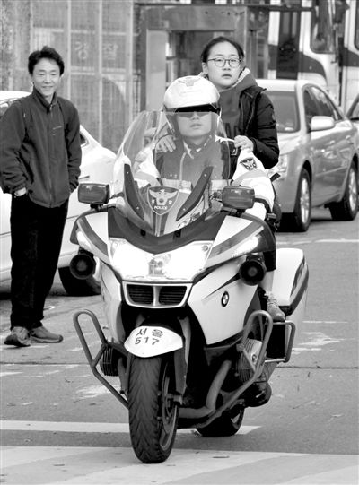 7日，首爾，警察將一名考生送抵考場。新華社發(fā)