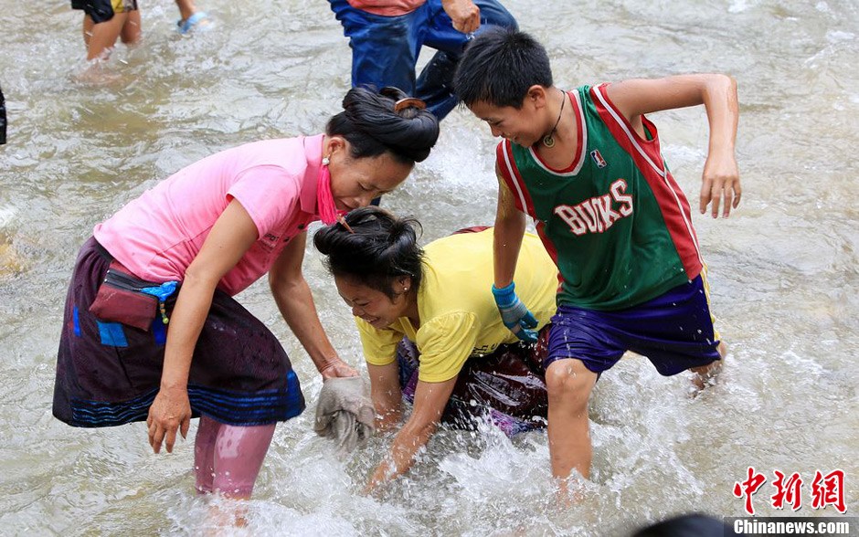 7月9日，村民在小河里摸魚搶魚。譚凱興 攝