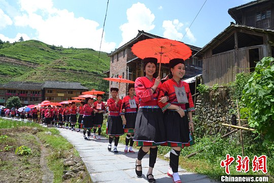 圖為新娘身著瑤族盛裝在伴娘和親友的陪伴下“出嫁”。中新社發(fā) 韋吉陽 攝