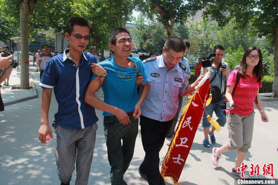 圖為獲救嬰兒父親情緒一度失控，當(dāng)?shù)鼐焦ぷ魅藛T對其進行攙扶。張一辰 攝