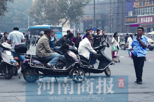 　火車站廣場北側(cè)，幾輛摩的正在等客