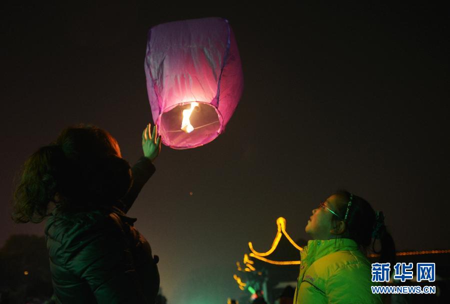 　1月30日，游客在江蘇省鎮(zhèn)江市金山公園門口放飛孔明燈。