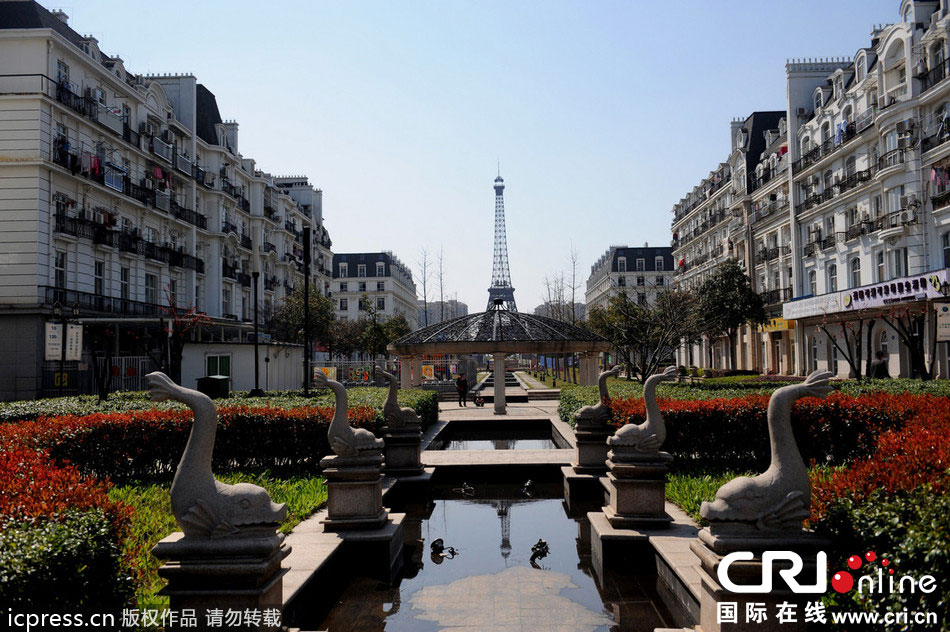 　2014年3月21日，杭州天都城，農(nóng)民在山寨埃菲爾鐵塔下耕作。圖片來源：東方IC