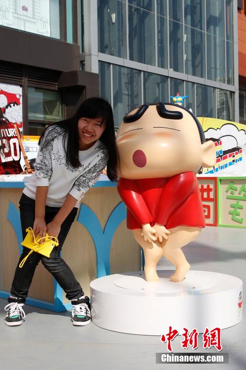 4月22日，游客與蠟筆小新合影。“蠟筆小新25周年紀(jì)念特展”日前在北京開(kāi)展，吸引了不少市民游客。
