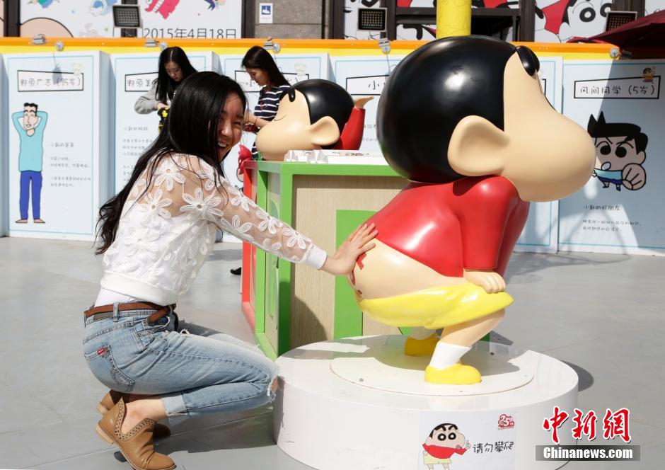 4月22日，游客與蠟筆小新合影?！跋灩P小新25周年紀(jì)念特展”日前在北京開(kāi)展，吸引了不少市民游客。