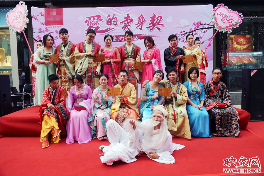 現(xiàn)場8對兒年輕男女舉起“賣身契”集體拍照。