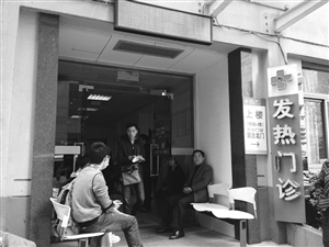 到浙大一院發(fā)熱門診就診的病人增多，不少人在門口等候