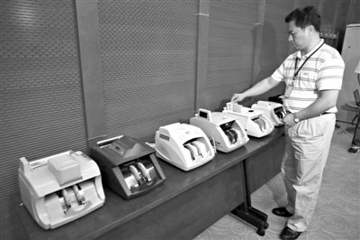 昨日，央行工作人員用各種驗(yàn)鈔機(jī)對(duì)C1F9假幣進(jìn)行測(cè)試，機(jī)器均能及時(shí)作出異常報(bào)警反應(yīng)。新京報(bào)記者 浦