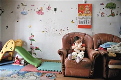 6月14日，未婚媽媽于軍的家里。女兒悅悅抱著兔子玩偶，在聽媽媽手機上的兒歌，這個4歲女孩喜歡兔子。