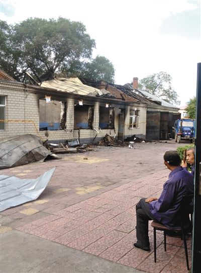 7月27日，海倫聯(lián)合敬老院內(nèi)，幾名老人看著對面被燒毀的特護病房。新京報記者 涂重航 攝