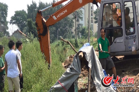 陳寶成手持自制刀斧守在挖掘機旁阻止便衣民警靠前。駕駛室內(nèi)，張朋珂正向受害人郭曉剛身上澆汽油。（視頻截圖）