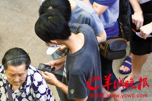 排隊(duì)的“黃?！备魇謭?zhí)一疊白紙，上面寫好了要掛號(hào)的人的信息，包括姓名、電話、要掛的科室等。穿黑白花紋衣服的老婆婆正在排隊(duì)掛號(hào)