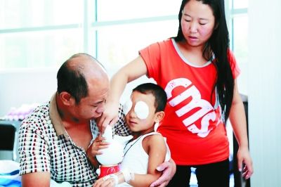 斌斌手術(shù)后第一天恢復(fù)良好，斌斌父母在用玩具逗他開心供圖/嚴(yán)益