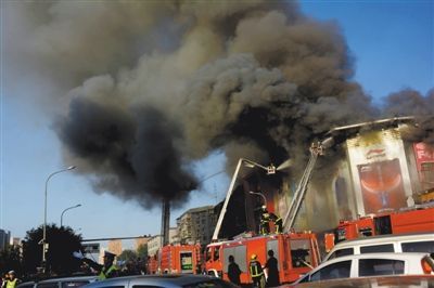 11日，蘋果園喜隆多商場(chǎng)，火災(zāi)現(xiàn)場(chǎng)濃煙滾滾。新華社發(fā)