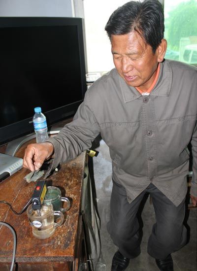 谷彥明用電解水質(zhì)檢測(cè)器進(jìn)行試驗(yàn)