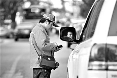 10月15日，朝陽區(qū)東大橋路，停車管理員從腰間掏出一個專用POS機(jī)，正在錄入停車信息。新京報記者 周崗峰 攝