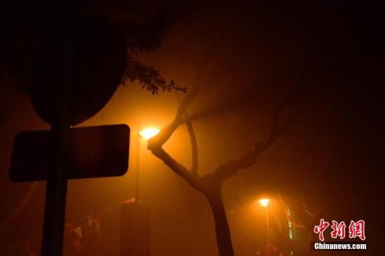 1月31日凌晨，市民行走在煙霧繚繞的南京街頭。當(dāng)天是農(nóng)歷馬年正月初一，南京有限開禁燃放煙花爆竹正逢下霧天，空氣的不流通致使煙花爆竹燃燒后產(chǎn)生的顆粒物不能及時散開，造成整座城市煙霧繚繞。據(jù)當(dāng)?shù)丨h(huán)保部門發(fā)布的信息顯示，空氣質(zhì)量屬重度污染。中新社發(fā) 泱波 攝