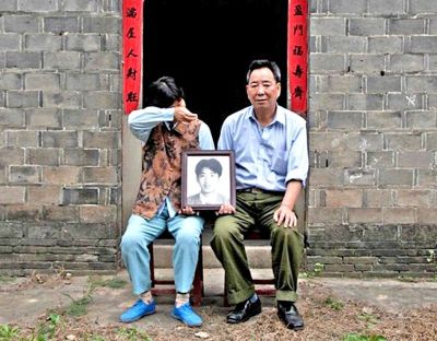 江蘇鎮(zhèn)江，老劉夫婦捧著獨生子的遺像在老家前留影南方都市報供圖L