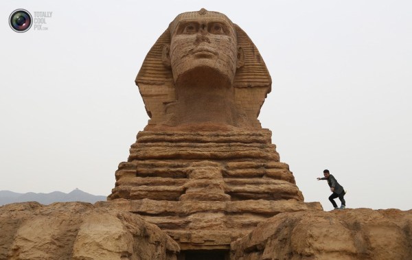 石家莊郊外，一名男子與山寨版獅身人面像合影留念。