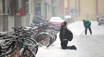 小伙子跪在樓前，一直抬頭看著樓上。 孫立國/攝