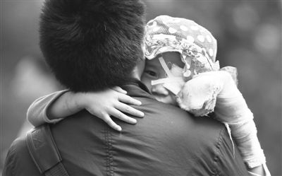 昨日，北京同仁醫(yī)院，被砍傷的彤彤趴在舅舅的肩上。他們剛剛掛完號，正準備回旅館。新京報記者 尹亞飛 攝