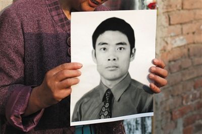 5月19日，朝陽(yáng)北路，母親捧著張東文的遺像。新京報(bào)記者 侯少卿 攝