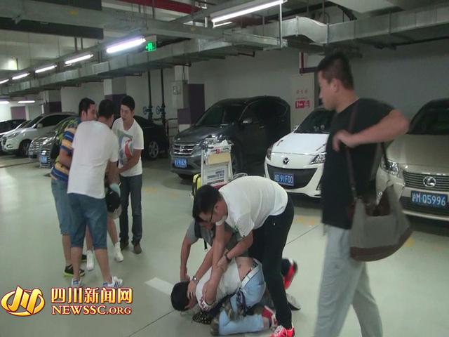 辦案人員在機(jī)場(chǎng)停車場(chǎng)抓獲胡某及其女友（警方視頻截圖）。