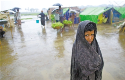 5月14日，緬甸若開邦實兌難民營，羅興亞族難民在雨中行走。熱帶風暴“馬哈森”即將登陸緬甸，這里的難民開始乘船撤離。