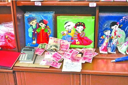 　　2012年6月21日，在朝鮮羅先特別市的一家商店里，柜臺(tái)上散落著一些人民幣。在朝鮮，人民幣比本國