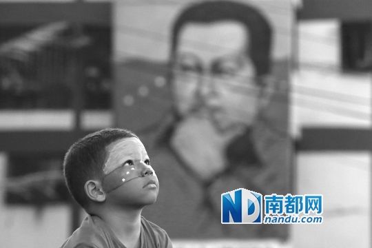 3月5日，一名委內(nèi)瑞拉兒童仰望天空，他身后是查韋斯的陵墓。
