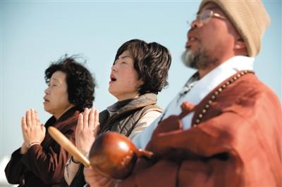 23日，一名僧侶引領(lǐng)人們?yōu)樗勒咂矶\。