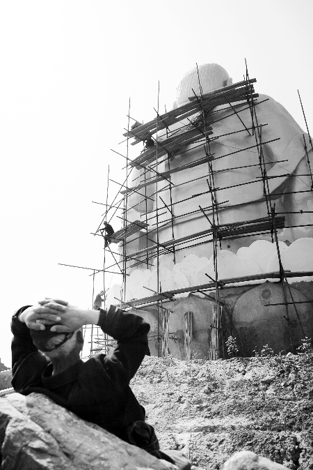 今年4月26日，工作人員將帆布蓋在“佛像”頭像上