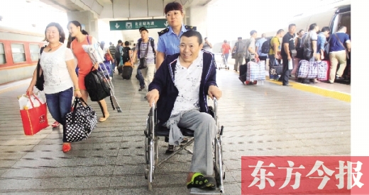 李剛手術后歸來，在車站工作人員幫助下走出鄭州火車站站臺  東方今報首席記者 張曉冬 攝