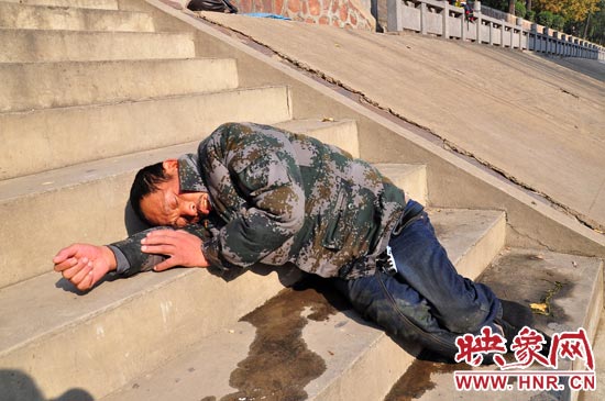 這名男子的衣服以及褲子全濕透了，水從衣褲里流出來，嘴里散發(fā)著濃烈的酒氣。