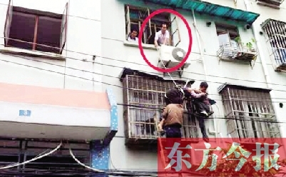 施救現(xiàn)場，劉鵬（圈內(nèi)）先用繩子捆住老太確保安全 勞動(dòng)報(bào)記者 郭娜 供圖