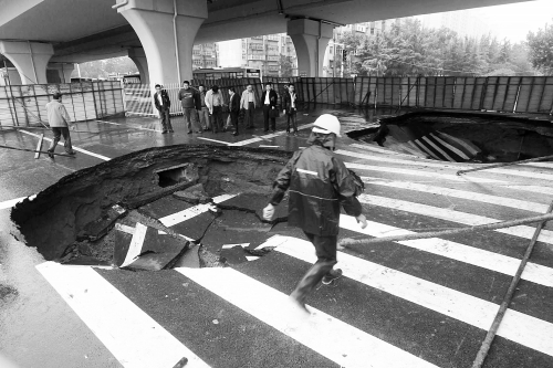 中原路西三環(huán)立交橋下由南向北原本4個車道，由于塌坑，而今3個車道被圍擋