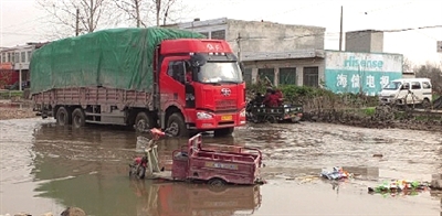 老人的電動(dòng)三輪車(chē)還陷在泥坑中