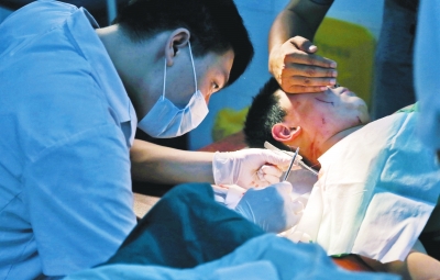 孩子身上有7道傷痕，其中兩道需要縫合，其他的均為擦傷，醫(yī)生正對(duì)他施治。