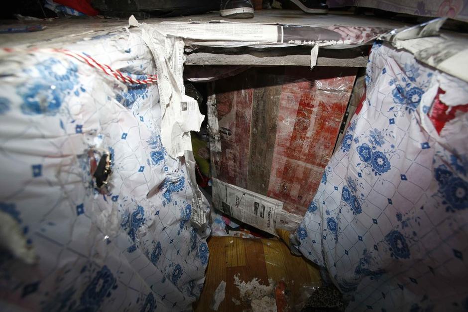 陳小龍在出租屋外，自行又圍起一堵圍墻，安裝了一個門。圍墻上都是豎起的鐵釘，外面堆著土，鄰居猜是從地底挖出來的。洞口就在床邊，0.5米見方，深約1.5米。洞口表面一塊紙板掩蓋，打開紙板跳入洞底，是一扇小木門，木門外有插銷，可以從外面鎖上。